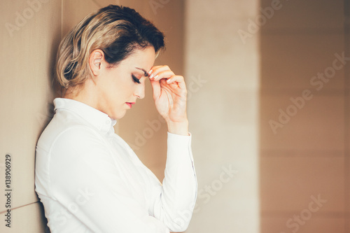 Thinking Hard Businesswoman Leaning on Wall