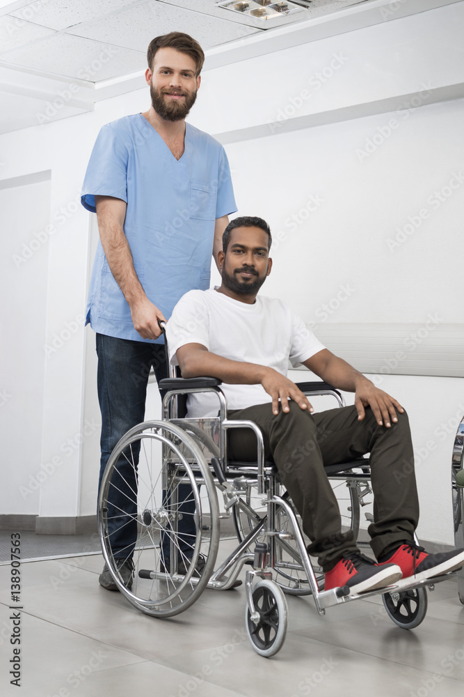 Patient Sitting In Wheelchair While Nurse Standing At Hospital Patient Sitting In Wheelchair While Nurse Standing At Hospital