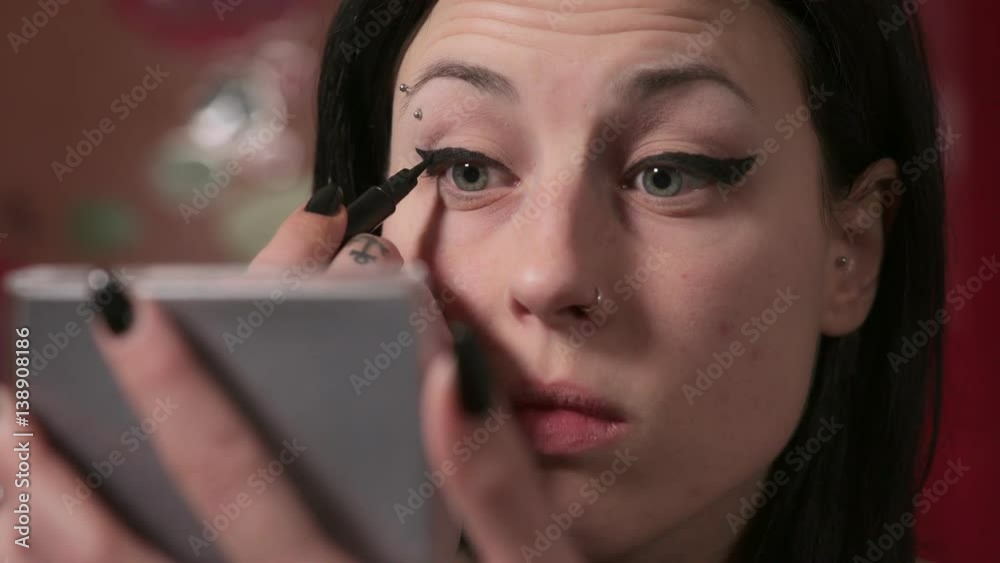 woman with piercing on the eyebrow intent on makeup eyes woman with piercing on the eyebrow intent on makeup eyes