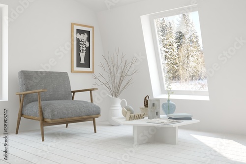 White room with armchair and winter landscape in window. Scandinavian interior design