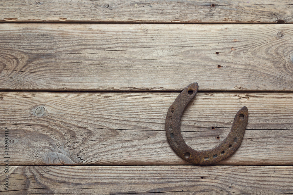 Rusty horseshoe on old wooden board. Rusty horseshoe on old wooden board.