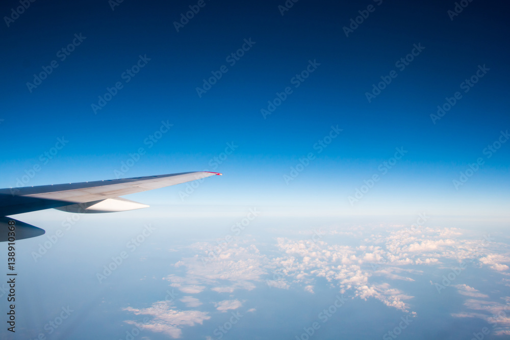 The wing of an airplane flying in the sky