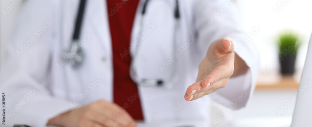 Female medicine doctor offering helping hand in office closeup. Physician ready to examine and save patient. Friendly and cheerful gesture. Medical cure and tests advertisement concept Female medicine doctor offering helping hand in office closeup. Physician ready to examine and save patient. Friendly and cheerful gesture. Medical cure and tests advertisement concept