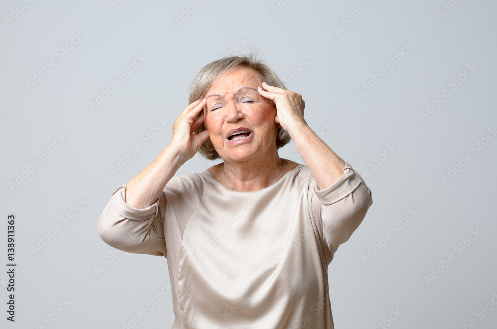 Senior woman with her hands to her temples Senior woman with her hands to her temples