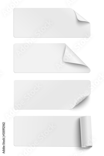 Set of oblong white sticky paper pieces. One piece has rolled end and others have curled corners  with shadow isolated on white background