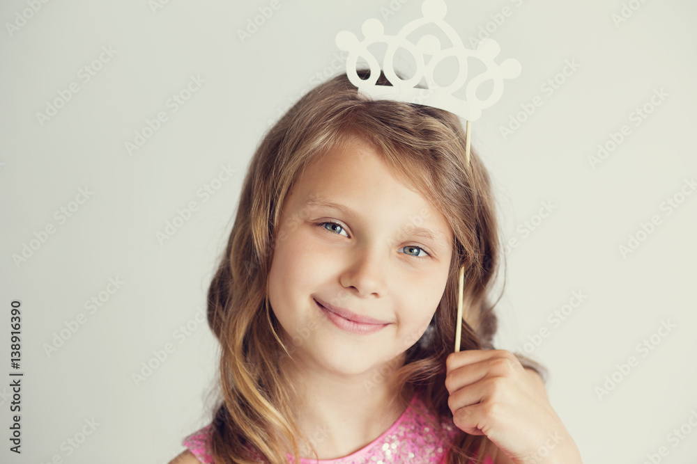 lovely little girl with white paper crown against a white background lovely little girl with white paper crown against a white background