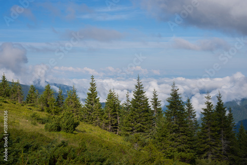 View at clouds that float over the green mountain valleys