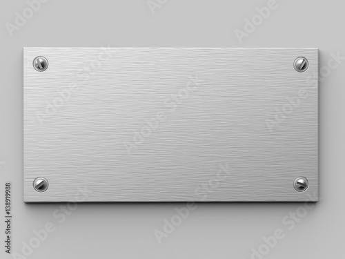 Blank brushed metal plate fixed on the white wall.