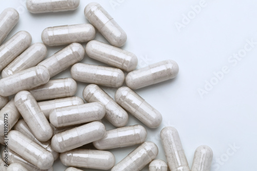 Pile of capsules with probiotic powder inside on white background. Top view, high resolution product.  Health care concept photo