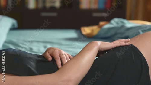 depressed woman lying alone in bed reflecting on the end of her love affair