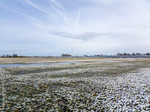 Last Snow covering field and grass under sky photo