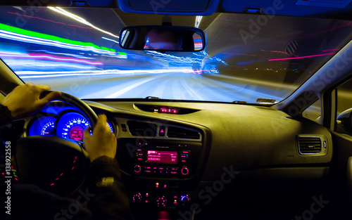 Night driving, view from inside car, city and other cars light is motion blurred.