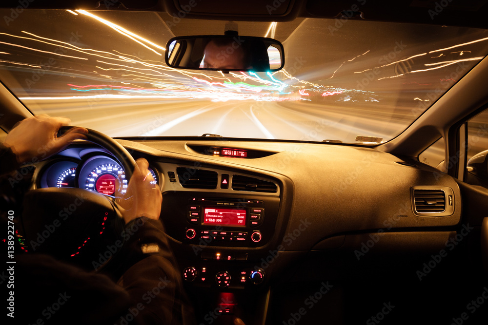 Night driving, view from inside car, city and other cars light is motion blurred.