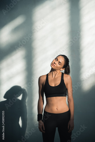 portrait of sporty woman with shadows stretching