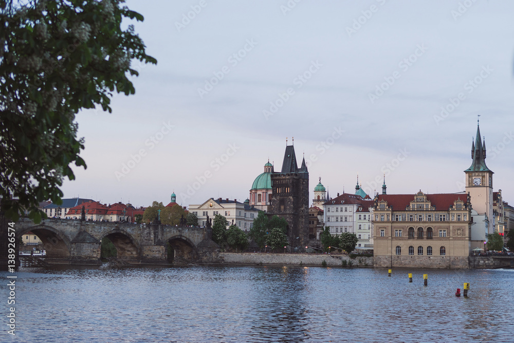 Prague cityscape in spring. View of old city center from the opposite bank of Vltava river after sunset