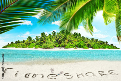 Whole tropical island within atoll in tropical Ocean and inscription "TimeShare" in the sand on a tropical island, Maldives.