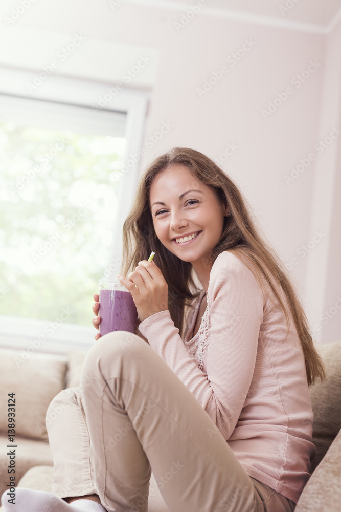Woman drinking blueberry smoothie Woman drinking blueberry smoothie