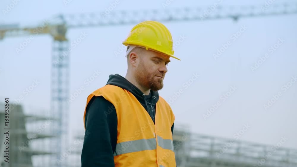 bald worker removes his helmet and looks at the camera seriously bald worker removes his helmet and looks at the camera seriously