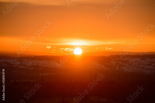 Sunset sky with the sun  with gold clouds