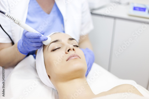 Skin care. Young woman receiving facial beauty treatment. Facial therapy. Anti-aging procedures.