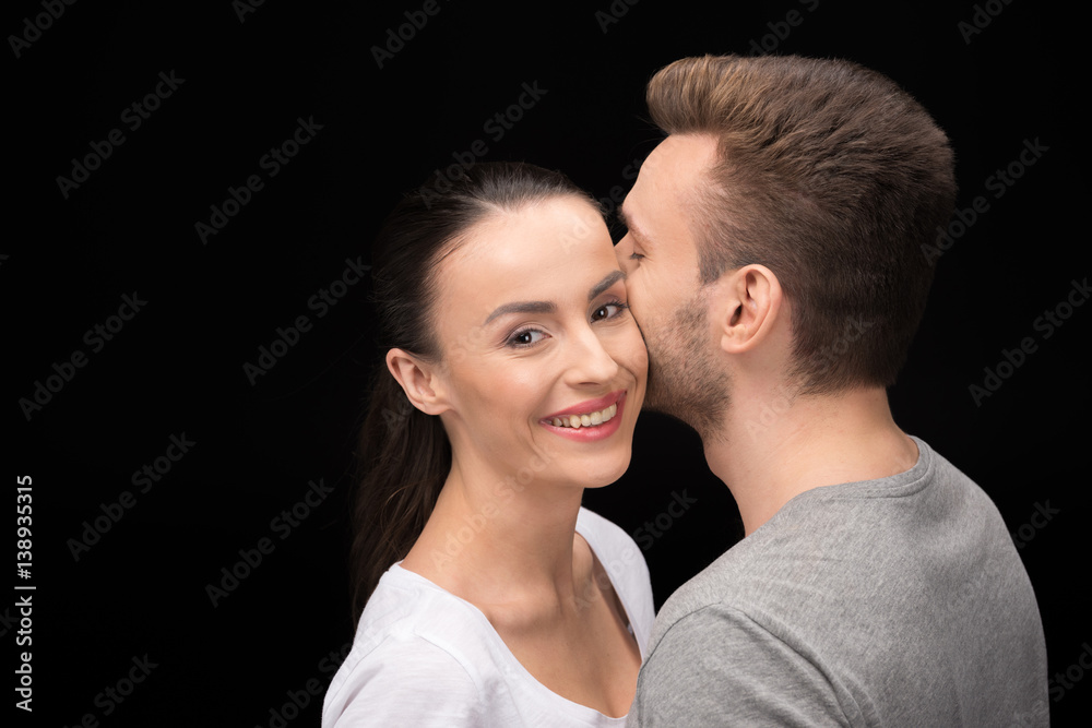 portrait of smiling woman looking to camera while bonding to man on black portrait of smiling woman looking to camera while bonding to man on black