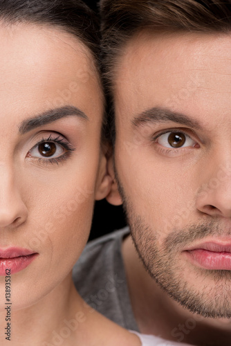 headshot of serious woman and man looking to camera on black