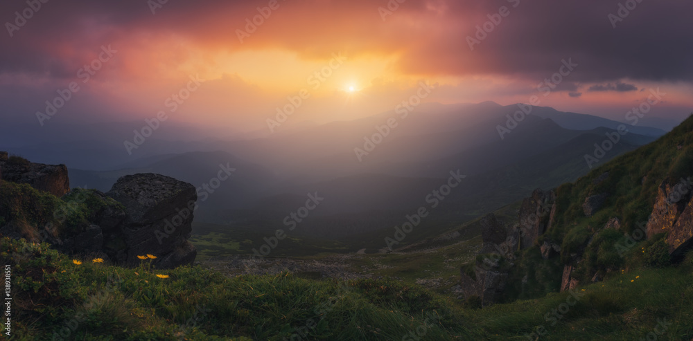 Naklejka premium Ukraine. Carpathians. Sunset over the Chernogorskiy ridge. Colorful sunset over the mountain peaks of the Carpathians, the mountain slopes are covered with green grass.