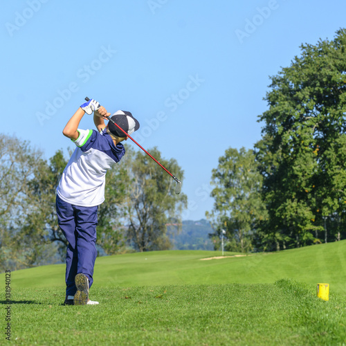 Jugendlicher beim Abschlag auf dem Golfplatz