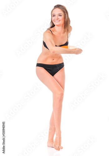 Happy young woman in a black bikini with flying disc, isolated on white background 