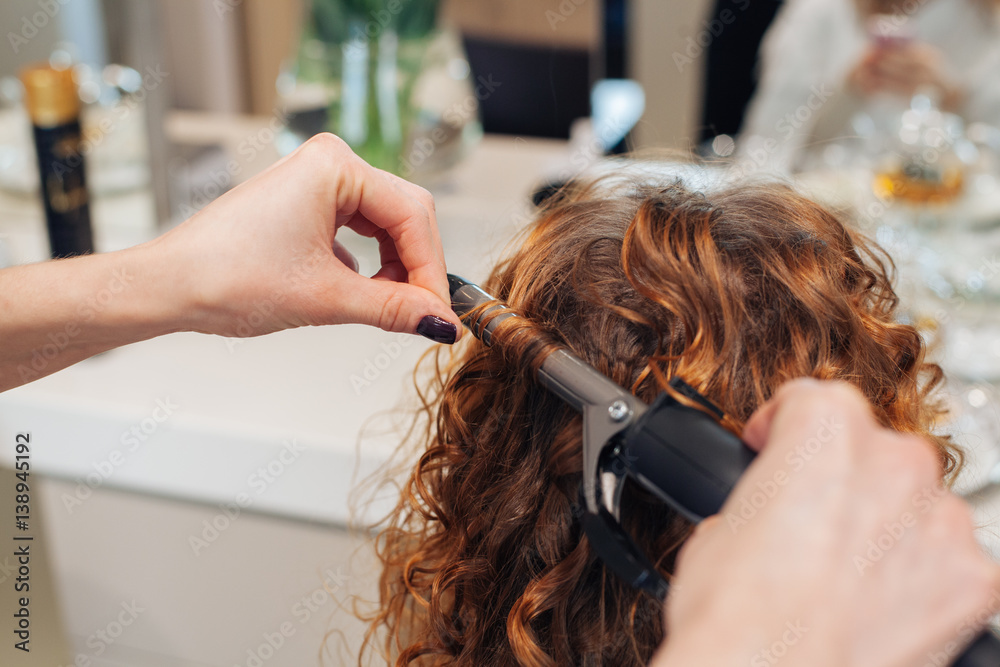 Fototapeta premium master in a beauty salon girl doing hairstyle