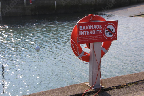 Panneau baignade interdite et bouée de sauvetage sur un quai  photo