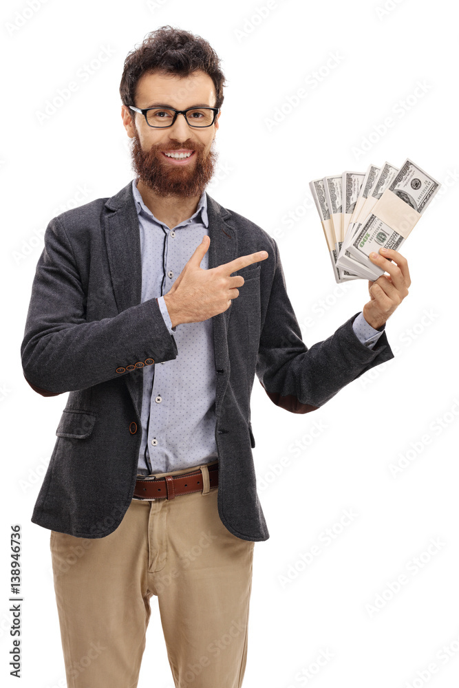Young man holding bundles of money and pointing Young man holding bundles of money and pointing