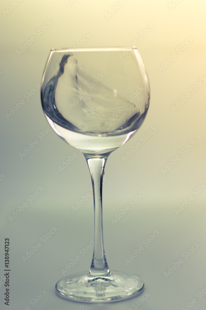 Splash water in a glass on a gray background Splash water in a glass on a gray background