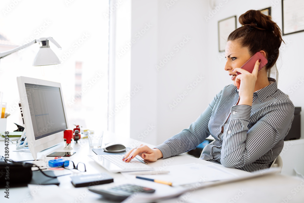 Obraz premium Happy businesswoman working at her desk