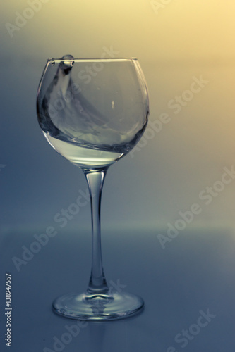 Splash water in a glass on a gray background