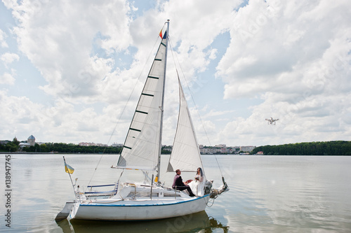 Wedding couple in love at small sailboat yacht on lake.