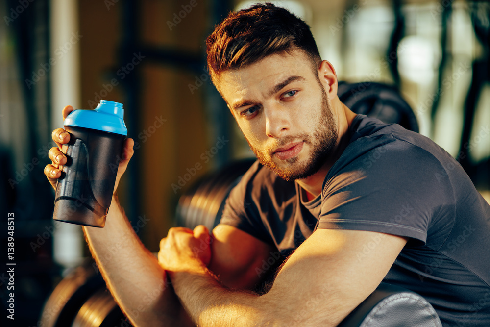 Naklejka premium Handsome man resting during a workout at the gym