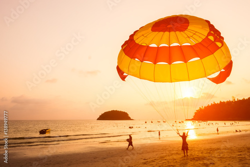 Silhouette of Parasailing at Kata beach with sunset background, Phuket, Thailand.