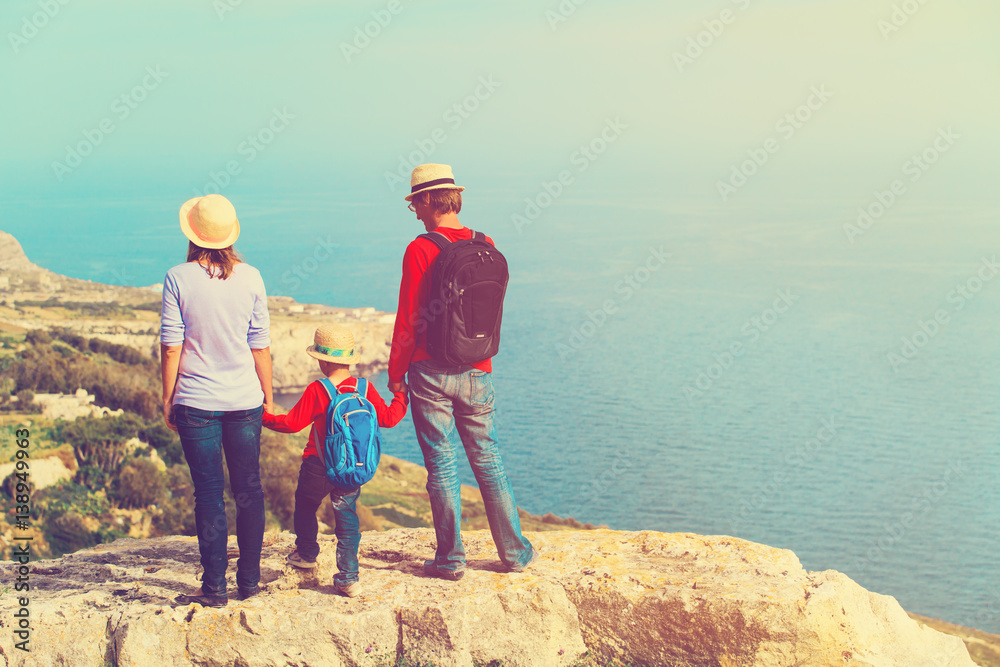 family with little child hiking in scenic mountains