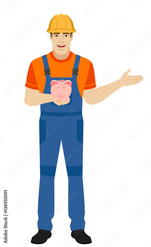 Builder holding a piggy bank and nd showing something beside of him Builder holding a piggy bank and nd showing something beside of him