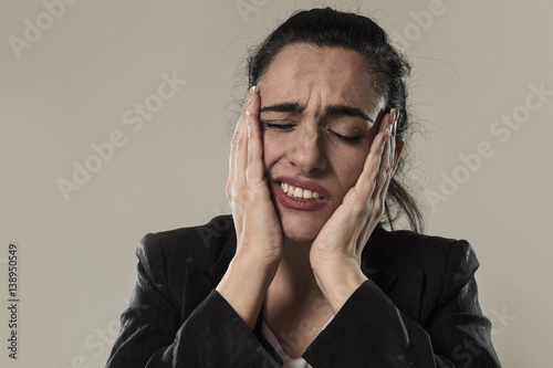business woman in office suit suffering migraine pain and strong headache