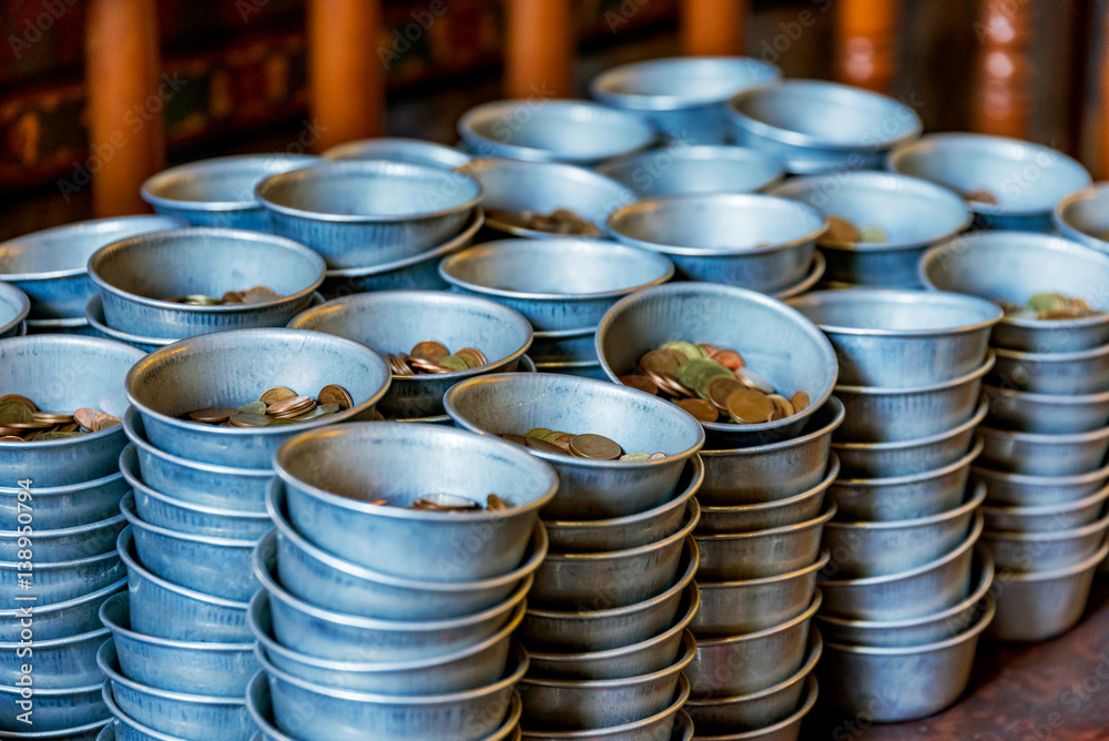 Coins in donation bowls for a buddhist temple Coins in donation bowls for a buddhist temple