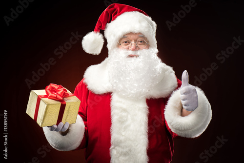 Santa Claus with gift box in hand © LIGHTFIELD STUDIOS