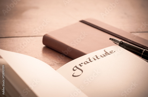 Notebook on Wooden Table - Gratitude Journal, Selective Focus, old fashioned look photo