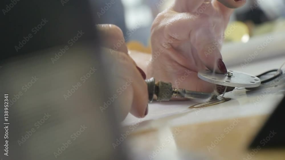 Woman Brazes Round Metal Details and Puts Aside Macro Woman Brazes Round Metal Details and Puts Aside Macro