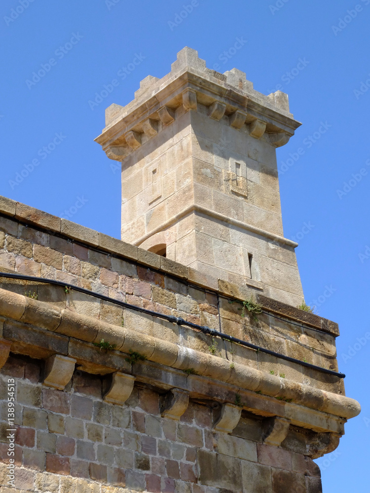 The stony small corner tower with castellation in Montjuic Castle on Montjuic mountain in Barcelona, Spain