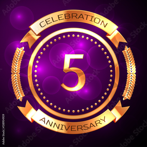 Five years anniversary celebration with golden ring and ribbon on purple background.