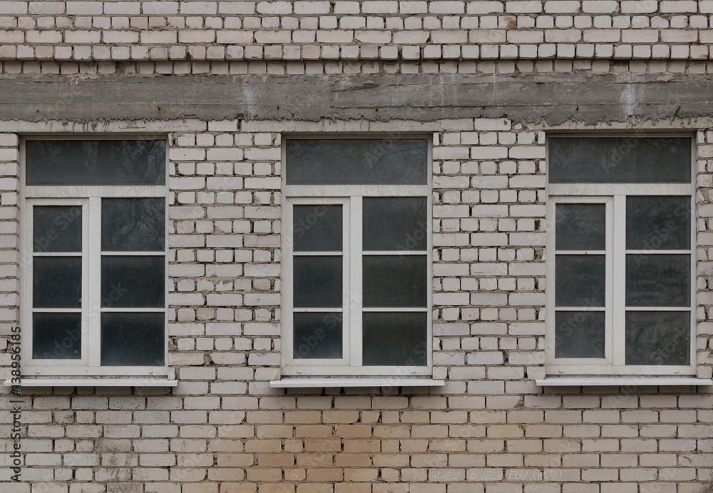 A dirty window in a brick wall.
