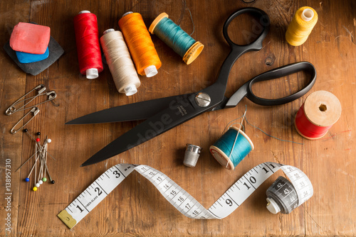 Sewing Tools and Spools of Thread on Wooden Surface