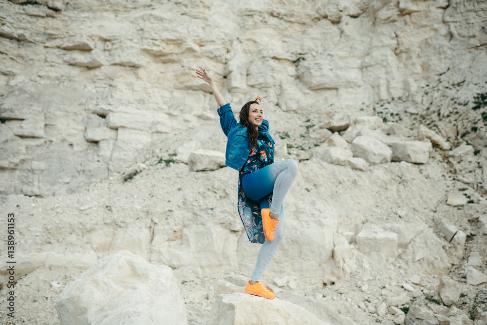 Young woman posing and dancing near the beautiful mountains dressed colorful clothes Young woman posing and dancing near the beautiful mountains dressed colorful clothes